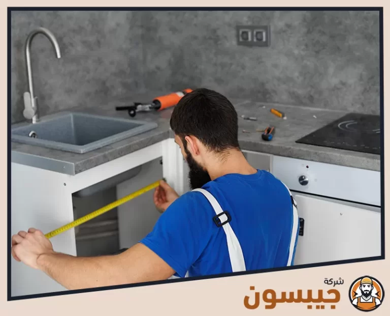 فني من شركة صيانة مطابخ المنيوم في الإمارات يقوم بقياس المساحة لتركيب أجزاء جديدة من المطبخ المنيوم
