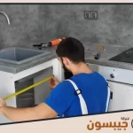 فني من شركة صيانة مطابخ المنيوم في الإمارات يقوم بقياس المساحة لتركيب أجزاء جديدة من المطبخ المنيوم